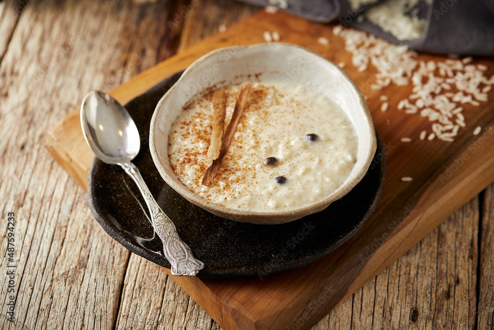 Arroz con leche with cinnamon, a typical Ecuadorian dessert served on a traditional plate on a white background. Arroz con leche with cinnamon, a typical Ecuadorian dessert served on a traditional plate on a white background.