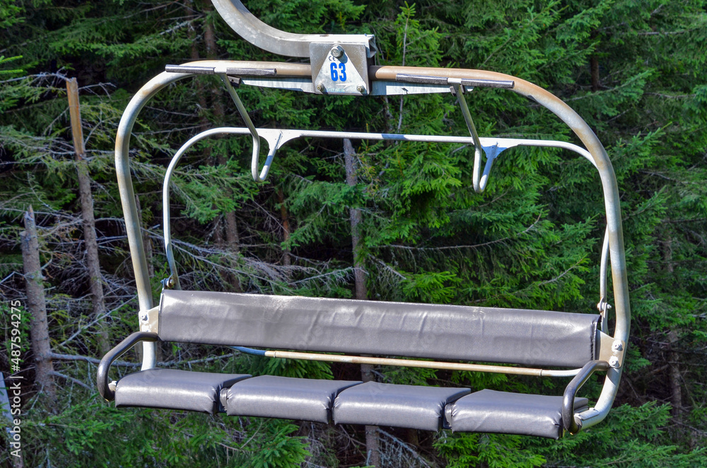 Empty chairlift with four seats ascending on mountain Empty chairlift with four seats ascending on mountain