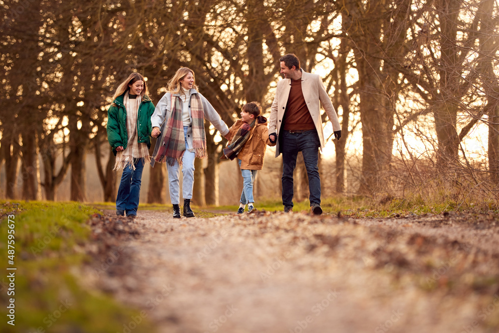 Family Holding Hands On Walk Through Autumn Countryside Together Family Holding Hands On Walk Through Autumn Countryside Together