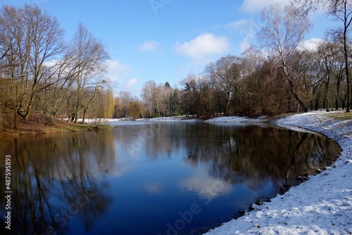 Early spring in the city park. Amazing view of the pond. City park in winter scenery. Beautiful little pond in early spring  © skorpionik00