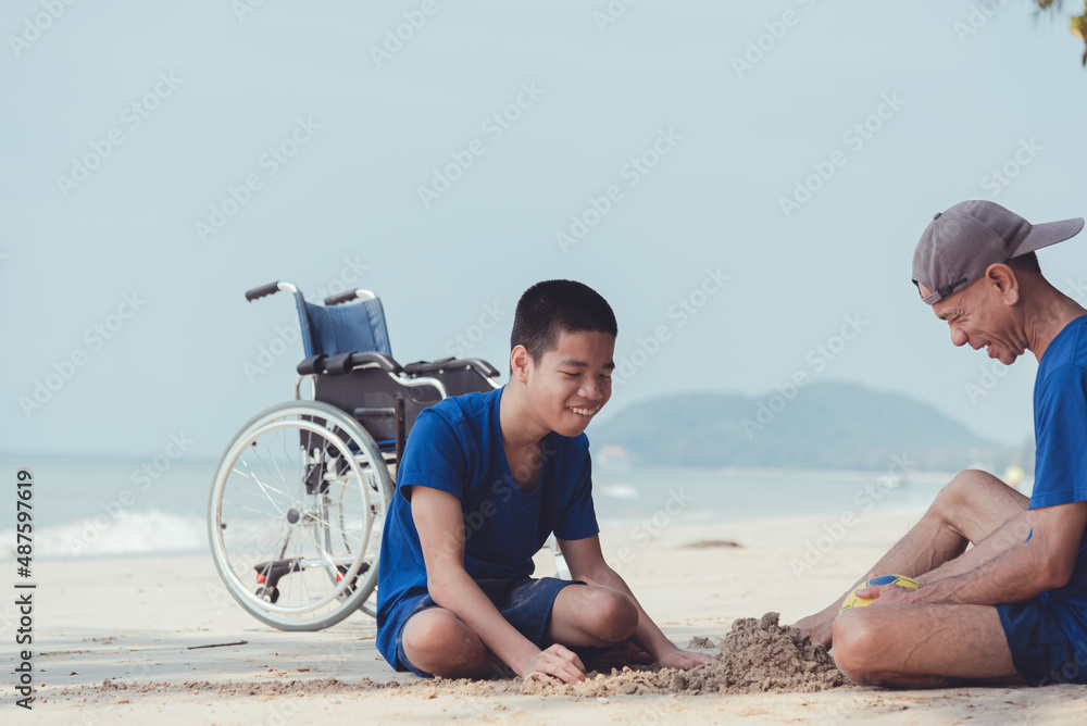 Fototapeta premium Young man with disability and parent or volunteer or caregiver relaxing and doing sea beach activities with family at the outdoor vacation in summer, People leisure travel and mental healthy concept.