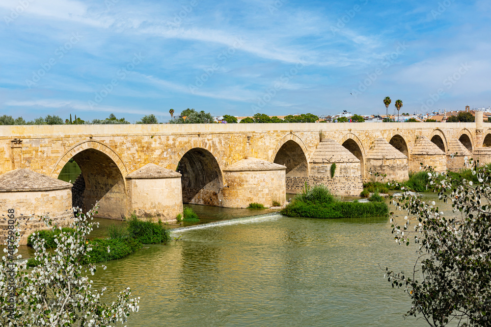 Cordoba, SPAIN - August 11, 2021:The Roman bridge of Córdoba, a stone bridge across the Guadalquivir river. Summer time.