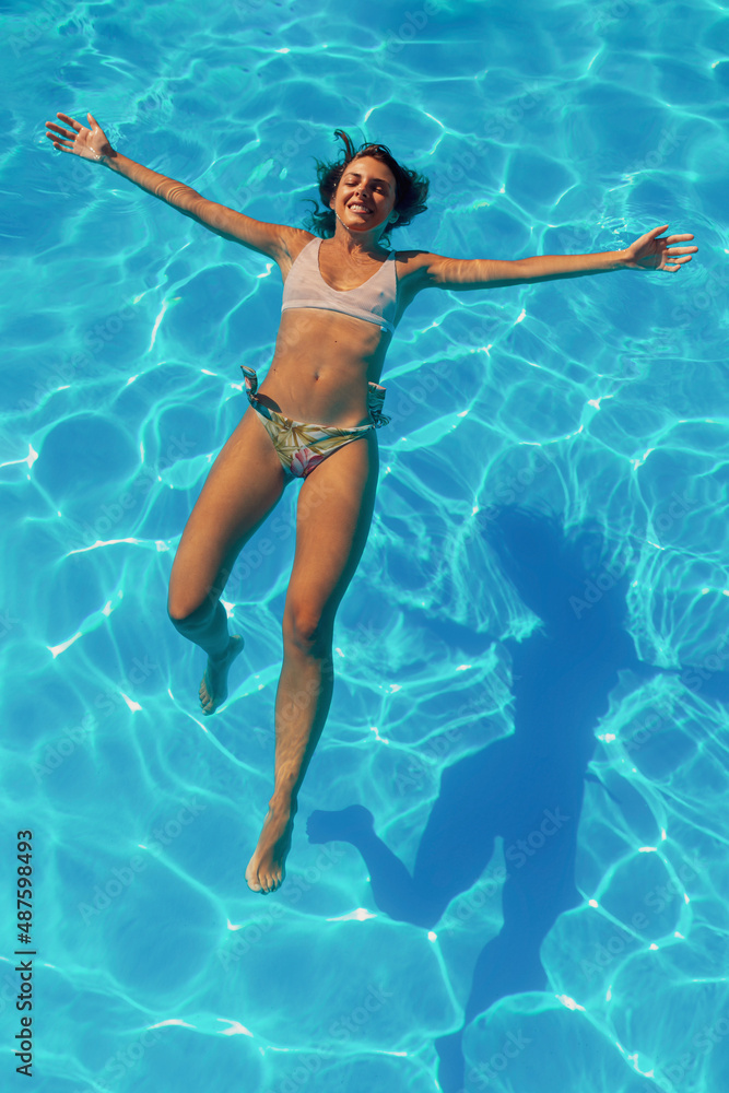 Woman floating on water while on summer vacation