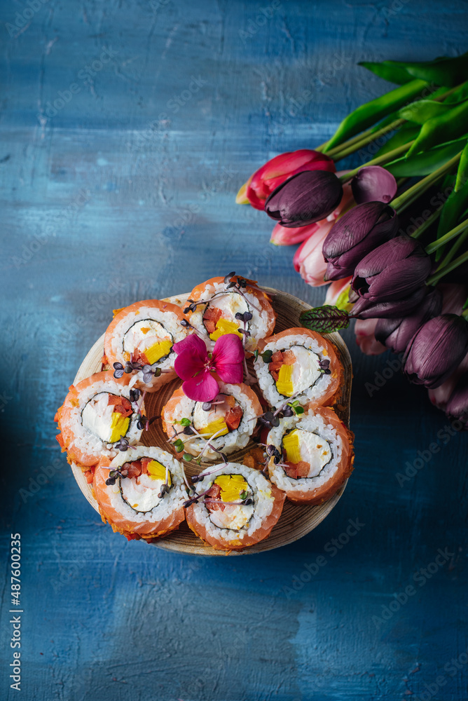 sushi on a small wooden tablein spring style with flowers tulips