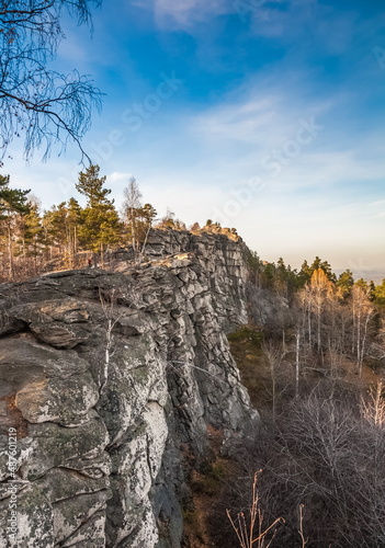 Autumn landscape with a stone ridge with trees against the sky