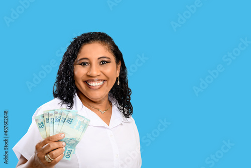 woman smiling holding brazilian money bills, positively surprised, space for text, person, advertising concept