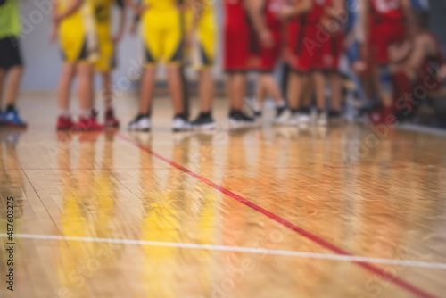 View of basketball court hall indoor venue with junior teenage school team playing in the background, basketball match game on arena stadium, team is blurred with copy space