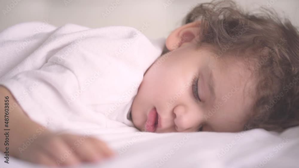Peaceful baby boy sleeping on bed. Two years old toddler sleeping alone. Motherhood. Sleeping baby concept. Baby, toddler development. Parenthood. Peaceful baby boy sleeping on bed. Two years old toddler sleeping alone. Motherhood. Sleeping baby concept. Baby, toddler development. Parenthood.