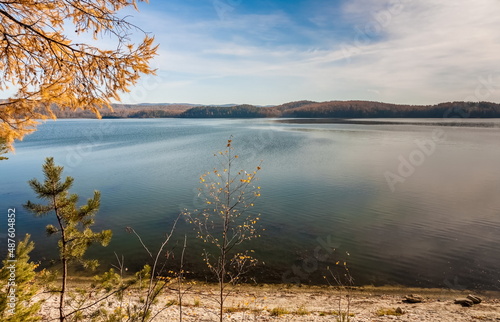 Fototapeta Naklejka Na Ścianę i Meble -  Autumn landscape with lake shore, trees, mountains and sky with clouds