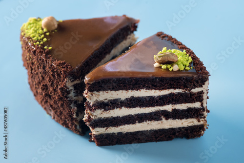 Homemade Chocolate Cake with Vanilla Cream on a Blue Background Decorated with Nuts Tasty Dessert Horizontal photo