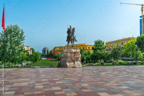 Tirana, Albania - June 21, 2021: Monument to Skanderbeg on the square in Tirana. Sculpture of the hero of Albania riding a horse on the backdrop of an urban landscape with a green park on a summer day