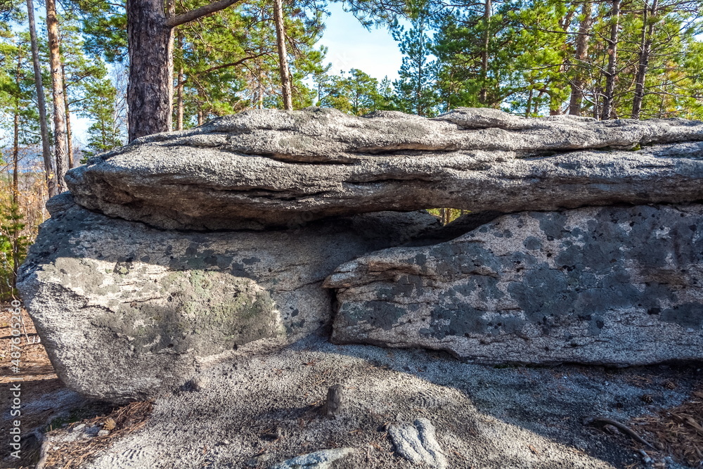 Autumn landscape with trees and rocks on top of a mountain against the sky