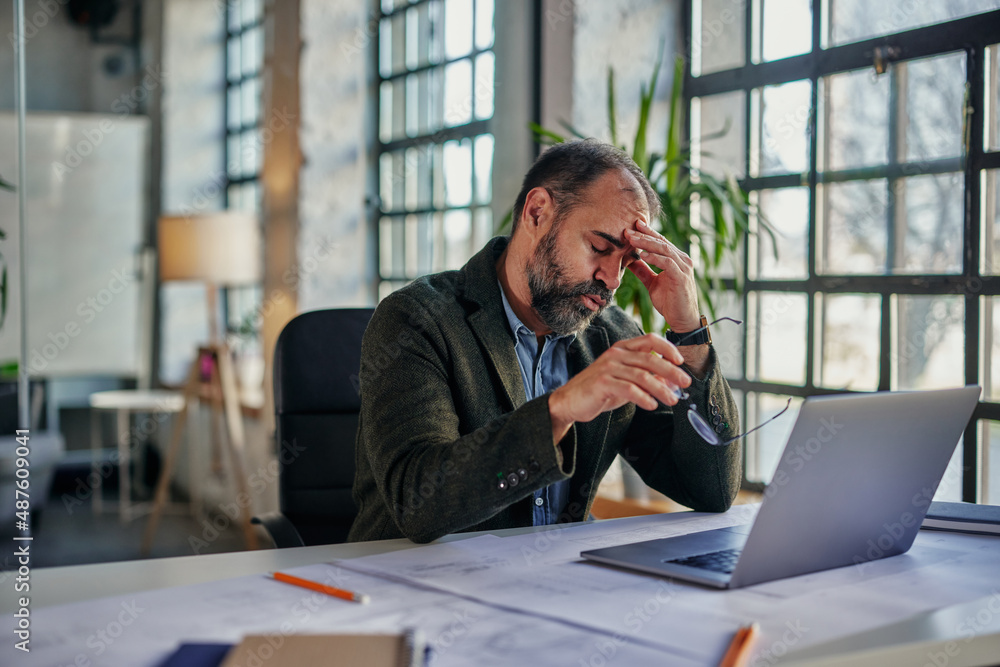 Exhausted middle adult businessman at work Exhausted middle adult businessman at work