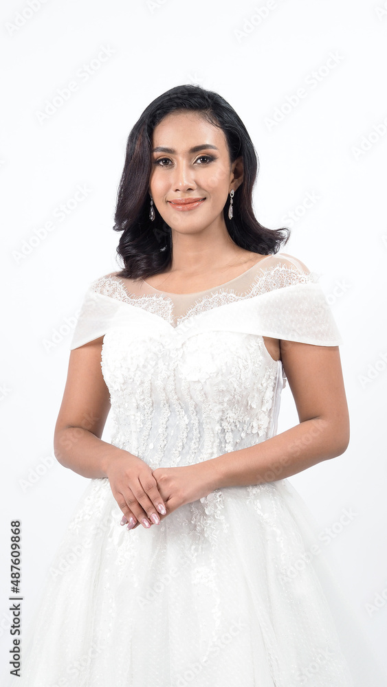 Asian woman in white wedding dress. Thai bride poses before the wedding day. A young woman is happy in a wedding dress. Portrait shot white background in studio. Marriage dress for marriage ceremony. Asian woman in white wedding dress. Thai bride poses before the wedding day. A young woman is happy in a wedding dress. Portrait shot white background in studio. Marriage dress for marriage ceremony.