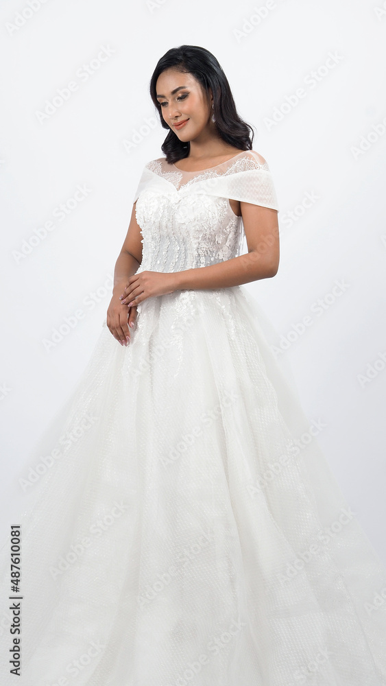 Asian woman in white wedding dress. Thai bride poses before the wedding day. A young woman is happy in a wedding dress. Portrait shot white background in studio. Marriage dress for marriage ceremony. Asian woman in white wedding dress. Thai bride poses before the wedding day. A young woman is happy in a wedding dress. Portrait shot white background in studio. Marriage dress for marriage ceremony.