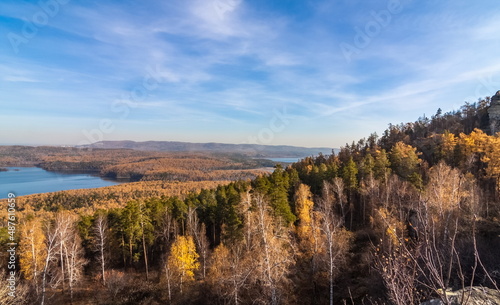 Autumn landscape from the top of a mountain with a lake, trees, mountains and sky