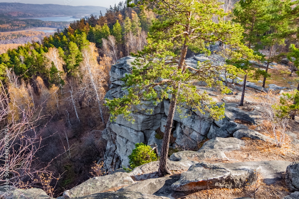 Obraz premium Autumn landscape with trees and rocks on top of a mountain against the background of lakes and forests