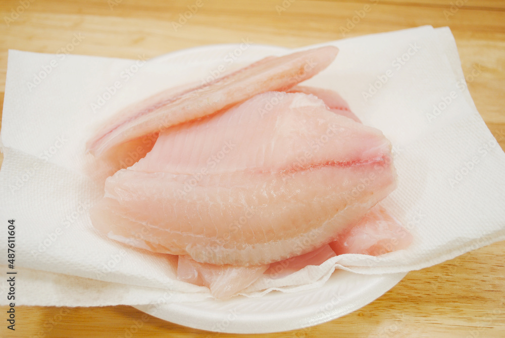 Raw Mild White Fish Drying on White Paper Towel Raw Mild White Fish Drying on White Paper Towel