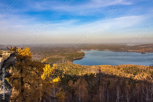 Autumn landscape from the top of a mountain with a lake, trees, mountains and sky © Александр Коликов