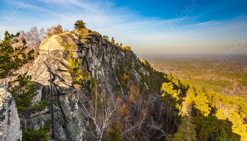 Autumn landscape from the top of a mountain with a lake, trees, mountains and sky