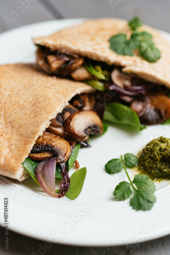 Pita breads filled with sauteed mushrooms and onions with winter purslane and corn salad, served with zhoug photo