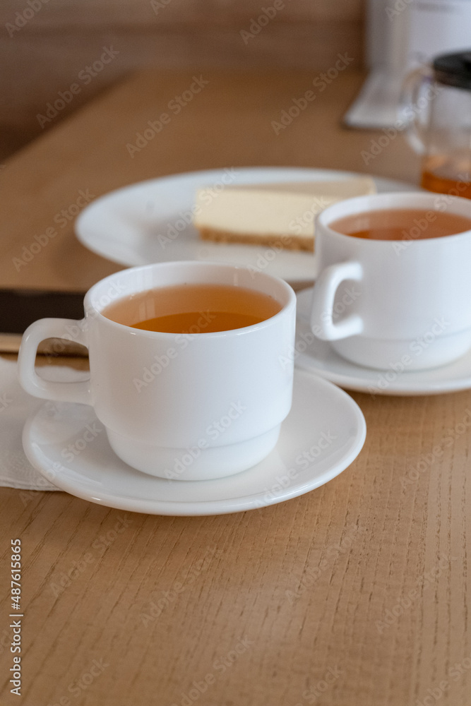 two cups of tea and cake cheesecake in cafe daylight lunch lunch snack vertical two cups of tea and cake cheesecake in cafe daylight lunch lunch snack vertical