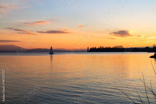 Petit voilier sur le Lac Léman au coucher du soleil depuis les berges à Morges (Canton de Vaud, Suisse) © Ldgfr Photos