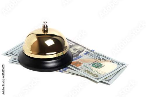 Gilded bell hotel service and hundred dollar bills white background.Conceptual hotel, travel and recreation.