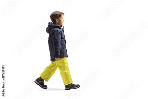 Full length profile shot of a boy in winter clothes walking