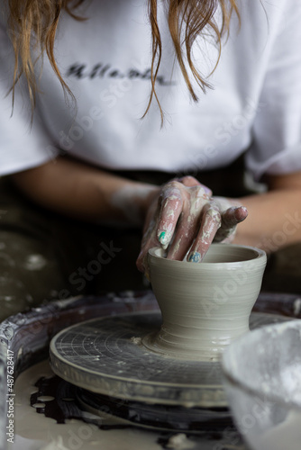 Young woman doing handmade pottery on the potter's wheel. Artist at work