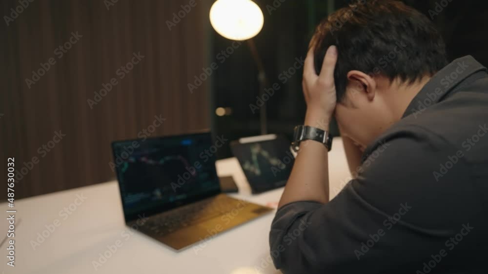 Young asian man feel disappointed after looking at trading charts, crypto currency trader on falling market, bear market, rug pull, liquidation of leverage future trading, fail sad evening Young asian man feel disappointed after looking at trading charts, crypto currency trader on falling market, bear market, rug pull, liquidation of leverage future trading, fail sad evening