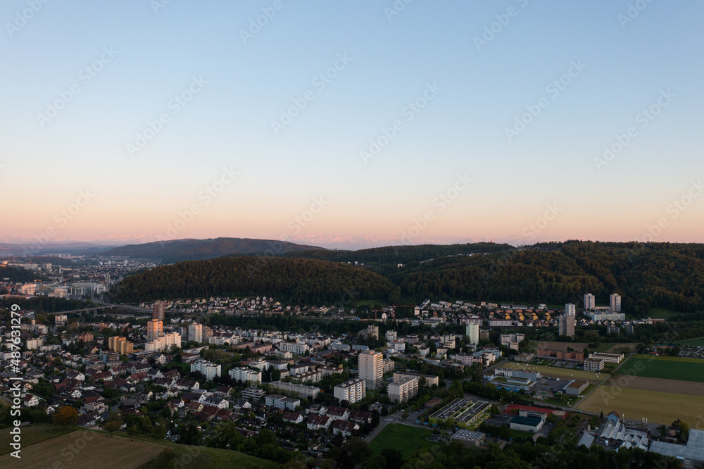 Amazing shot of a beautiful landscape in the alps of Switzerland. Wonderful flight with a drone over an amazing landscape in the canton of Aargau. Epic view at sunset over a village called Nussbaumen.