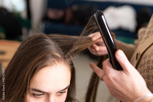 Shaping hairstyles by a hairdresser using a styler.