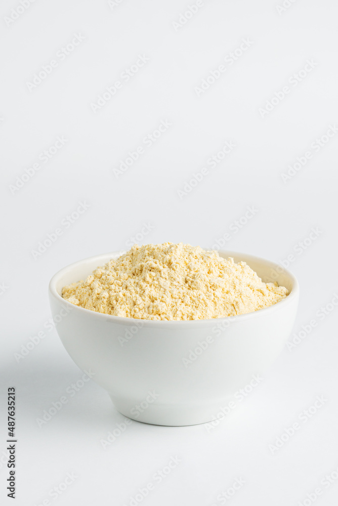 Chickpea flour or soy flour in white bowl on white background, top view Chickpea flour or soy flour in white bowl on white background, top view