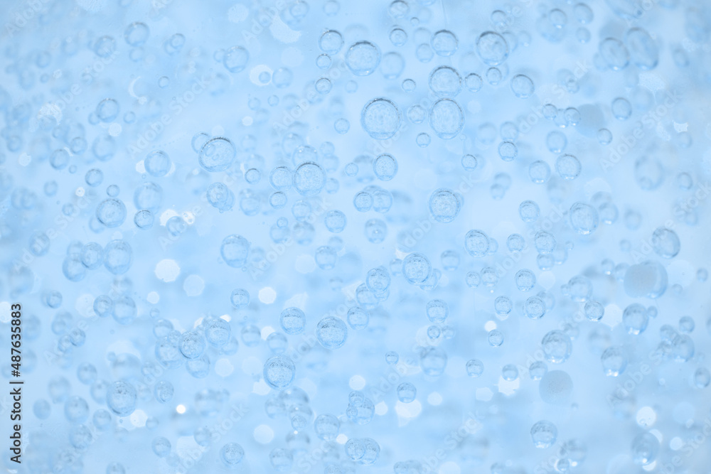 Light blue transparent texture of cosmetic gel or face serum as background with bubbles and copy space. Bath gel background