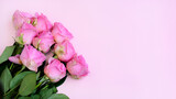 Top view, a bouquet of pink roses on a light pink background. Celebration atmosphere. Greeting card or invitation. copy space