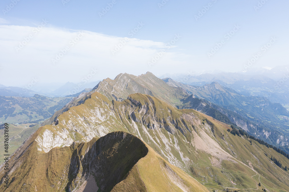 Fototapeta premium Amazing shot of a beautiful landscape in the alps of Switzerland. Wonderful flight with a drone over an amazing landscape in the canton of Bern. Epic view over a lake called Brienzersee.