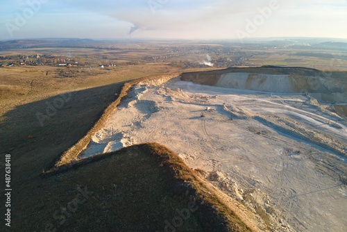 Aerial view of open pit mine of sandstone materials for construction industry with excavators and dump trucks. Heavy equipment in mining and production of useful minerals concept