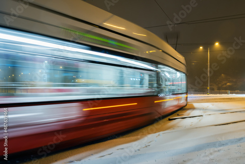 Red tram in motion.