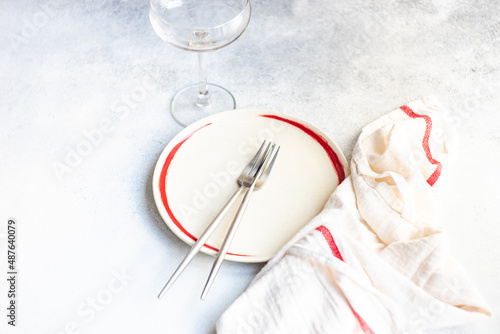 Overhead view of a minimalistic place setting and napkin with a red stripe photo