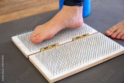 female feet on sadhu board with nails yoga meditation