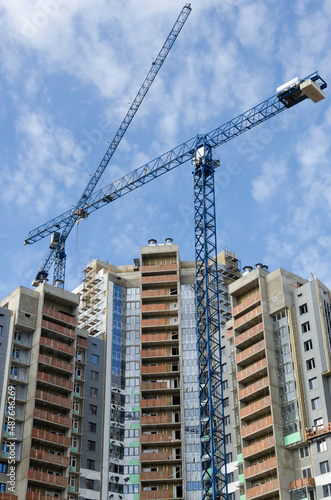 Blue construction cranes against the spring blue sky.