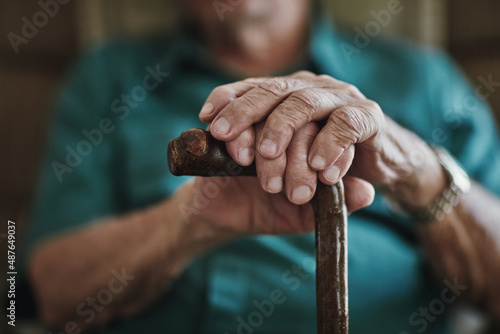 Getting older can bring senior health challenges. Cropped shot of an unrecognizable man leaning on his walking stick. © Nola V/peopleimages.com