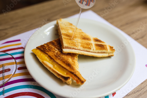 ham and cheese sandwich baked on a plate on a wooden table