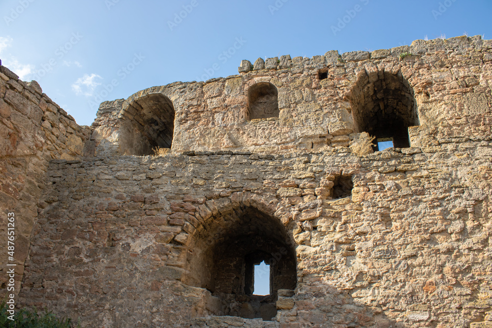 Holes for medieval guns in a defensive fortress. Space for protection in stone walls. The point of warfare in the citadels. Details of architecture.