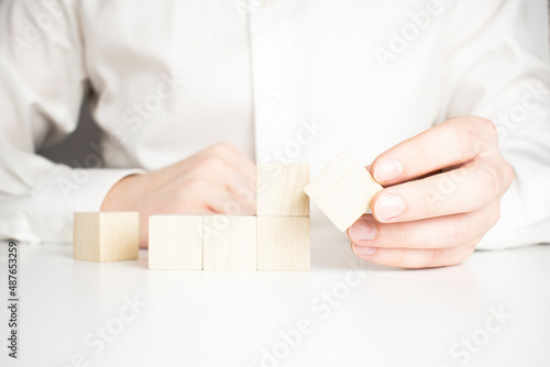Hand holding blank wooden block cubes on table background, business concept background, mock up, template, banner