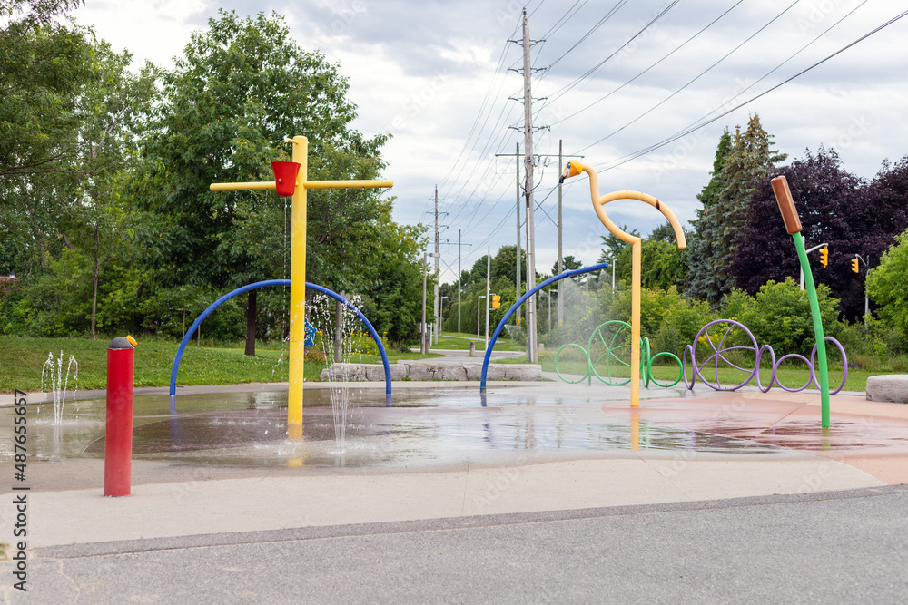 Splash pad playground in public park in summer without people. Fountains with splashing water