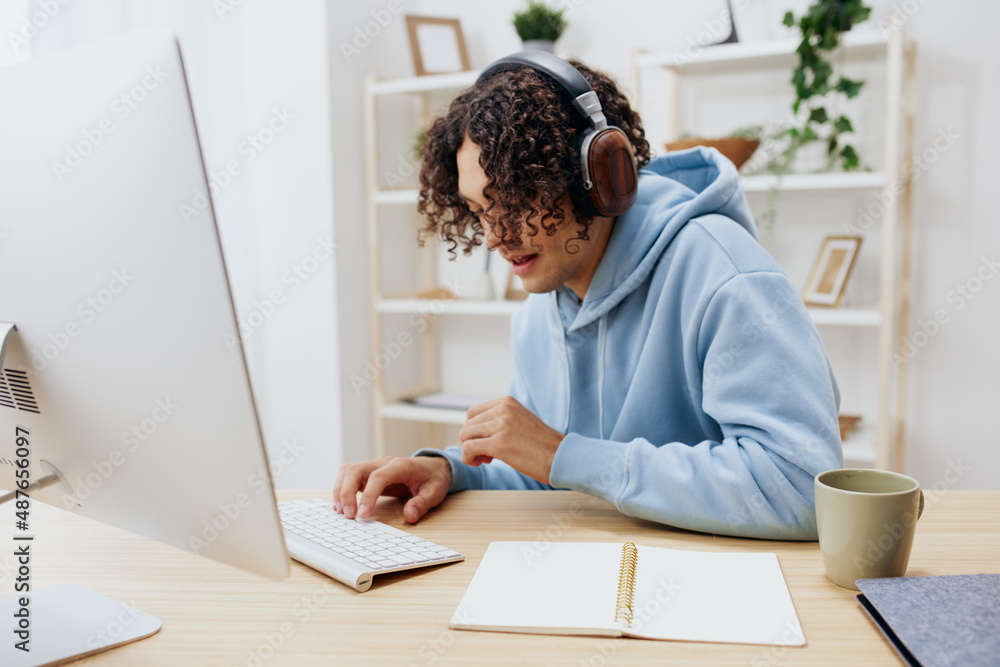 A young man in a blue jacket in front of a computer internet online Lifestyle A young man in a blue jacket in front of a computer internet online Lifestyle
