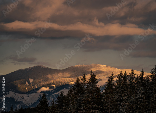 Amazing sunset. Winter forest. High mountains with snow white peaks. Location place Carpathian, Vatra Dornei, Bucovina, Suceava, Romania, Europe.