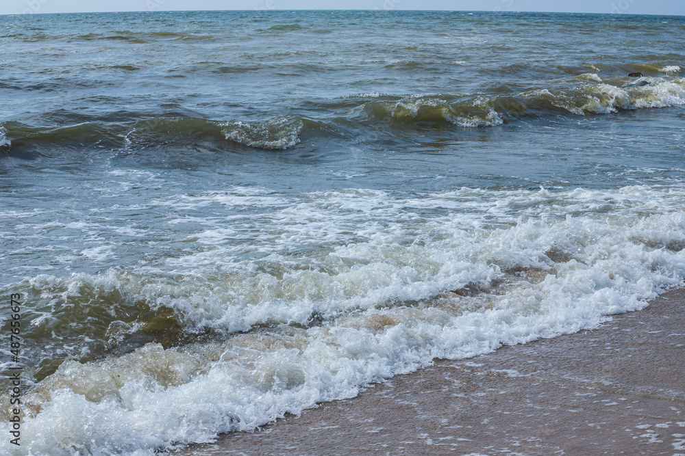 Sea wave with spray and foam near the shore